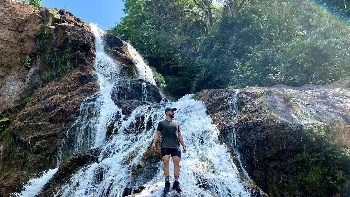 Ein Mann steht vor einem Wasserfall