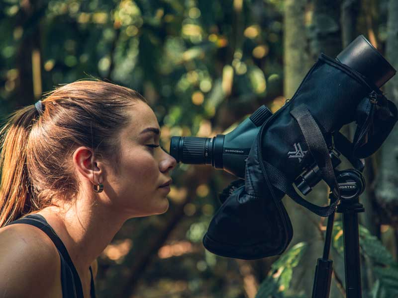 Eine Frau schaut durch ein Fernglas.