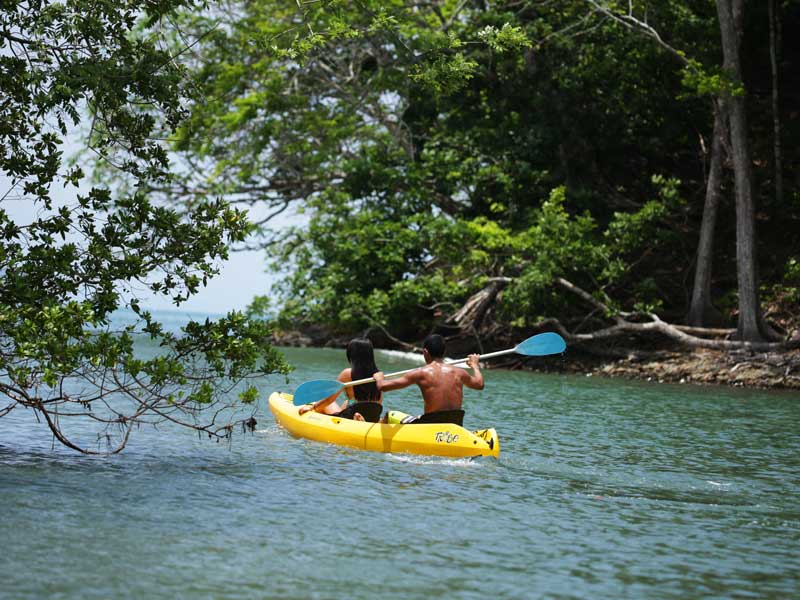 Ein Mann paddelt mit einem Kajak auf dem Wasser.