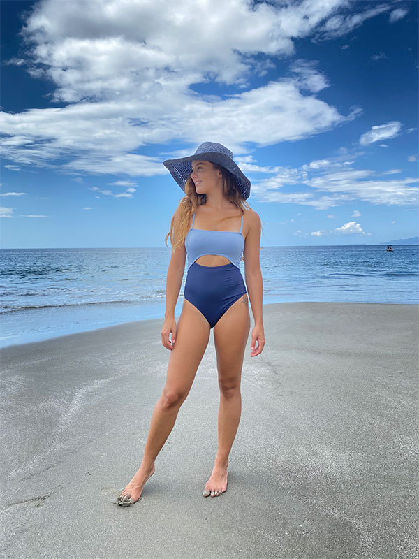 Eine Frau steht im Bikini am Strand.