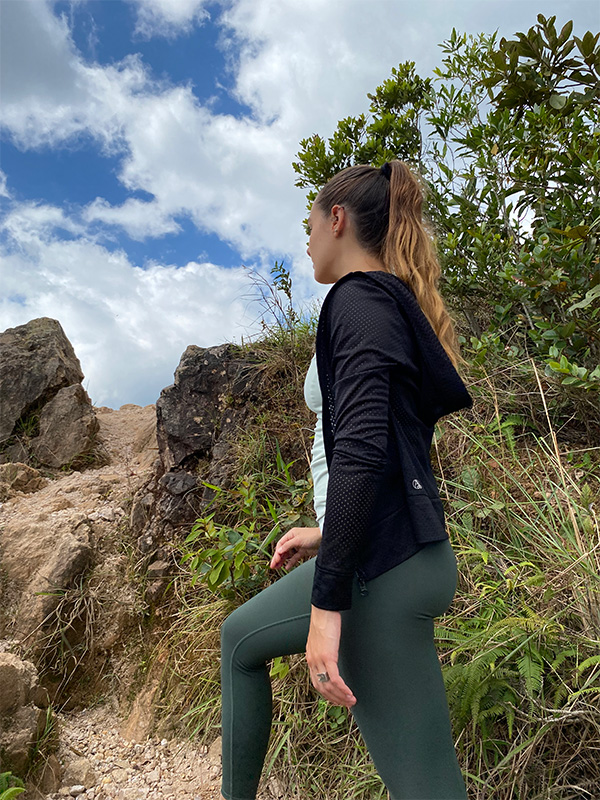Eine Frau in einem schwarzen Oberteil und grünen Leggings