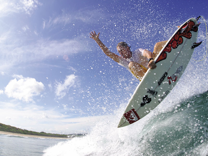 Ein Mann reitet auf einer Welle auf einem Surfbrett.
