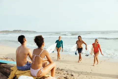 Freunde, die nach dem Surfen am Strand von Guiones aus dem Wasser kommen