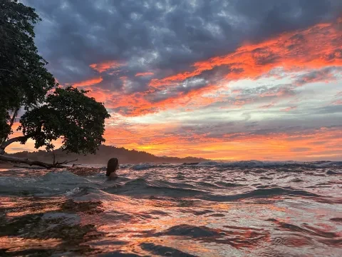 Eine Person im Meer bei Sonnenuntergang