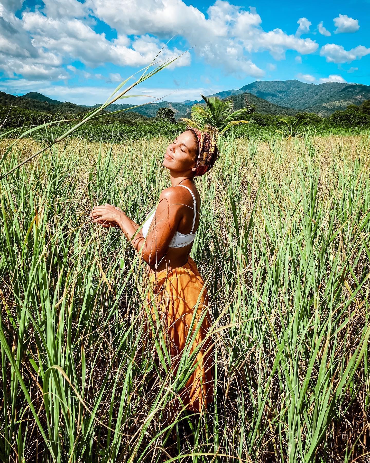Eine Frau steht in einem Feld mit hohem Gras