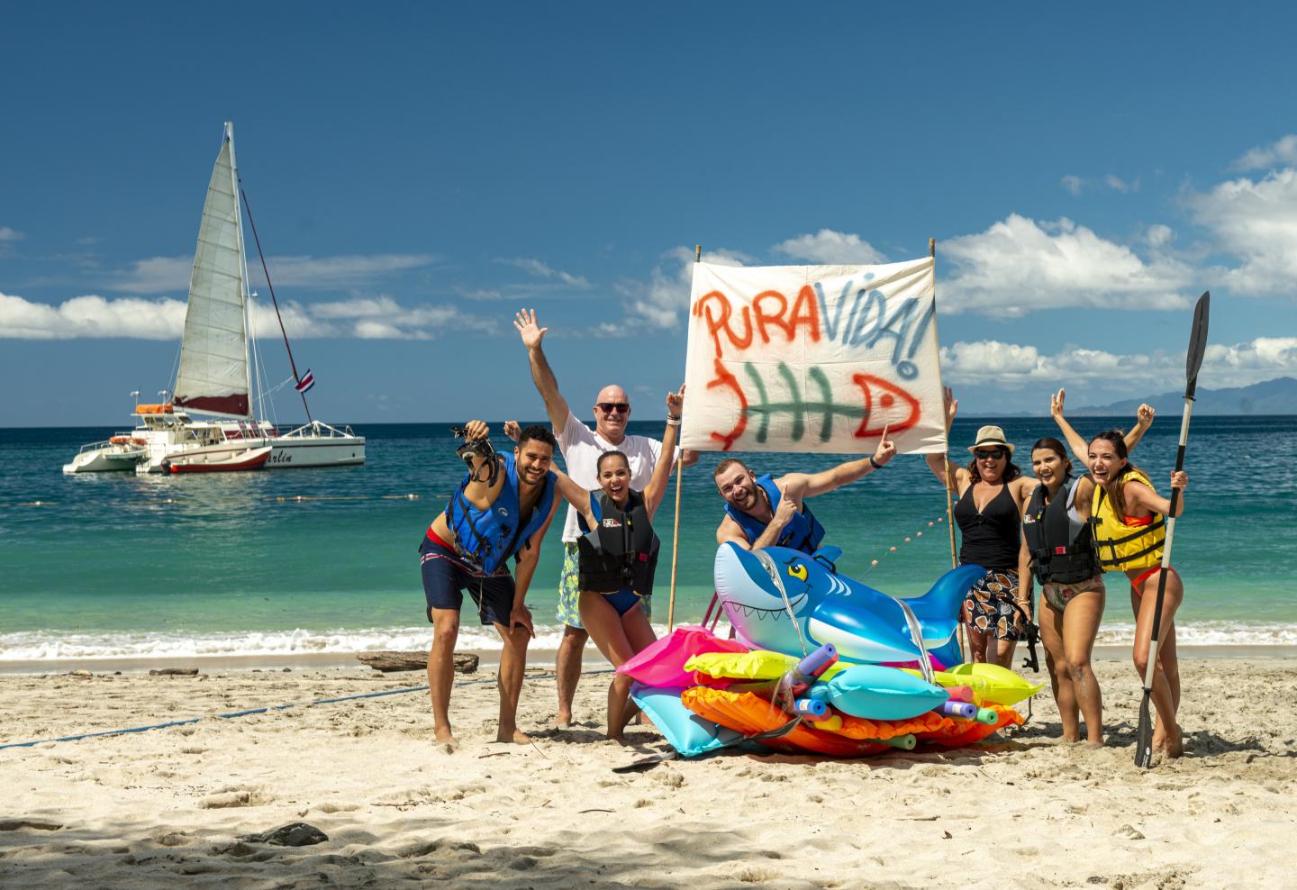 Menschen am Strand mit einem pura vida